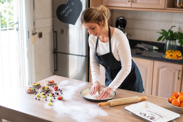 Giovane pasticcere che cucina una torta dolce in cucina