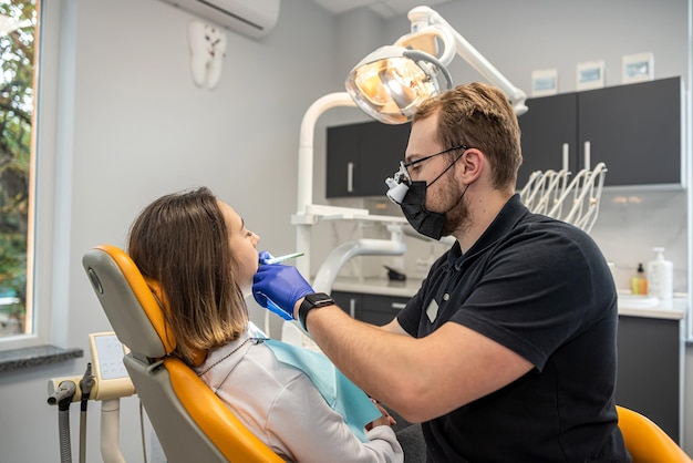 giovane paziente femminile si siede in una sedia da dentista nel suo ufficio