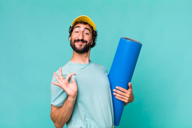 Giovane pazzo ispanico adulto con un tappetino per lo yoga