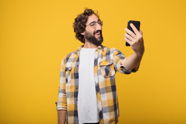 Giovane pazzo pazzo pazzo posa con un telefono cellulare intelligente