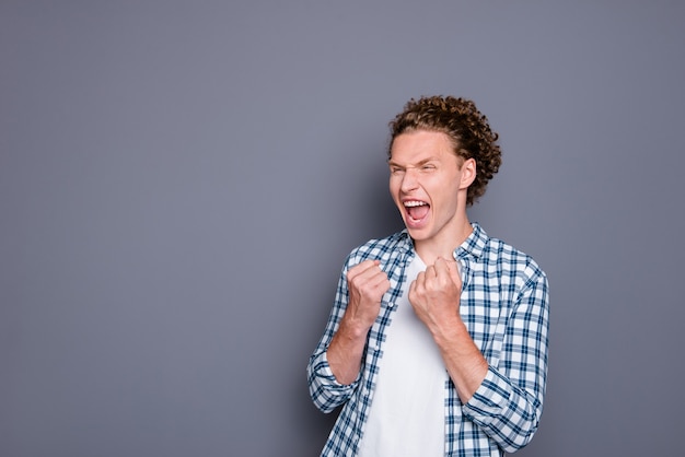 Giovane pazzo positivo in camicia a scacchi casual