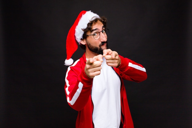 Giovane pazzo uomo barbuto con cappello santa. Concetto di natale