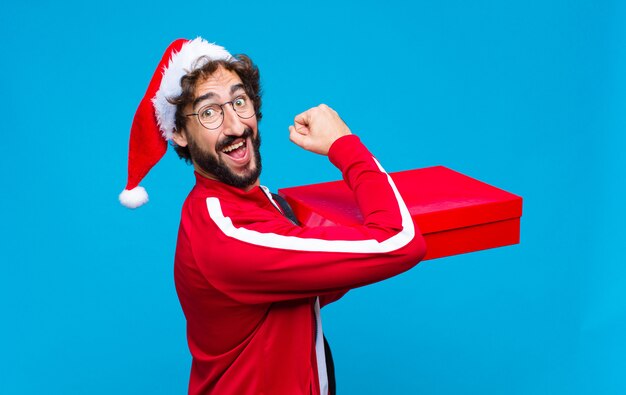 Giovane pazzo uomo barbuto con cappello santa. Concetto di natale