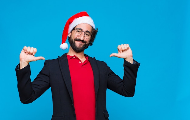 Giovane pazzo uomo barbuto con cappello santa. Concetto di natale