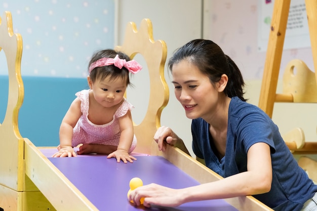 Giovane piccolo bambino asiatico che gioca in palestra con sua madre