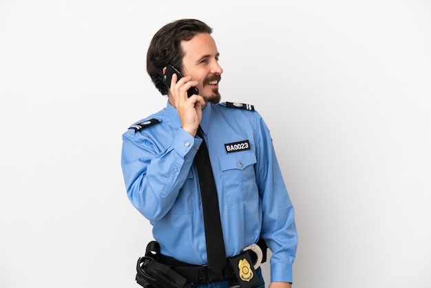 Giovane poliziotto su sfondo bianco isolato mantenendo una conversazione con il telefono cellulare con qualcuno