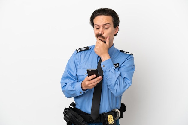 Giovane poliziotto su sfondo bianco isolato pensando e inviando un messaggio