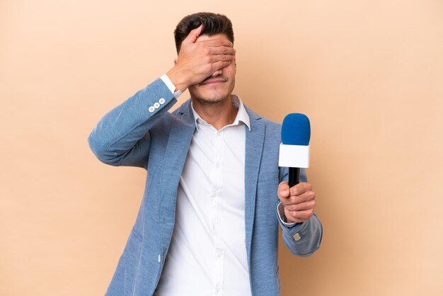 Giovane presentatore televisivo caucasico isolato su sfondo bianco che copre gli occhi con le mani Non voglio vedere qualcosa