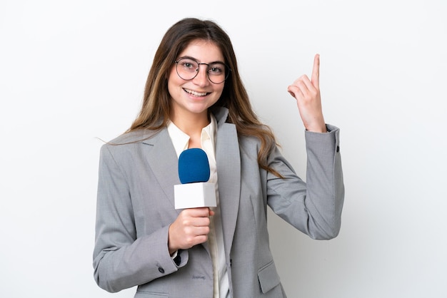 Giovane presentatrice televisiva caucasica isolata su uno sfondo bianco che indica una grande idea