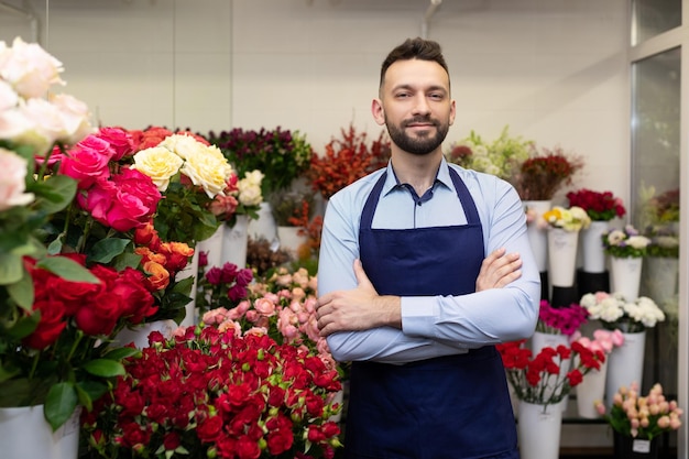 Giovane professionista del fiorista in frigorifero con fiori freschi