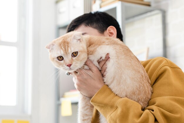 Giovane proprietario femminile che tiene in braccio un adorabile gatto