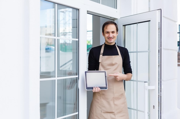 Giovane proprietario maschio che utilizza tablet digitale mentre si trova in negozio