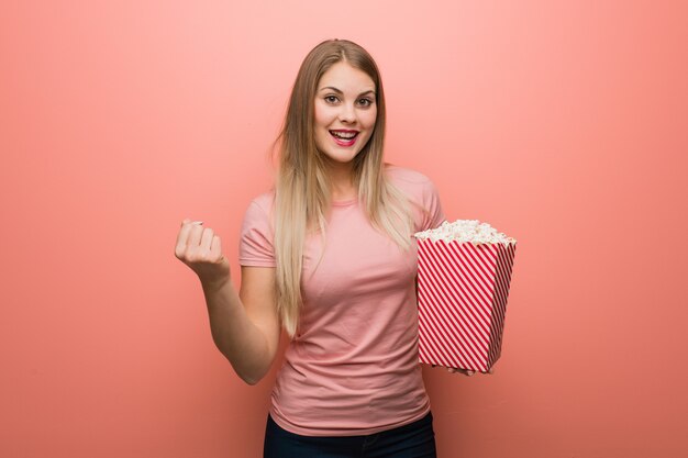 Giovane ragazza abbastanza russa sorpresa e scioccata. Ha in mano i popcorn.