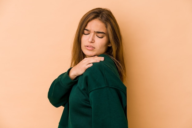 Giovane ragazza adolescente caucasica magra che ha un dolore alla spalla.