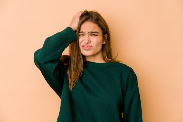 Giovane ragazza adolescente caucasica magra stanca e molto assonnata tenendo la mano sulla testa.