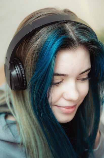 Giovane ragazza adolescente con capelli blu e cuffie