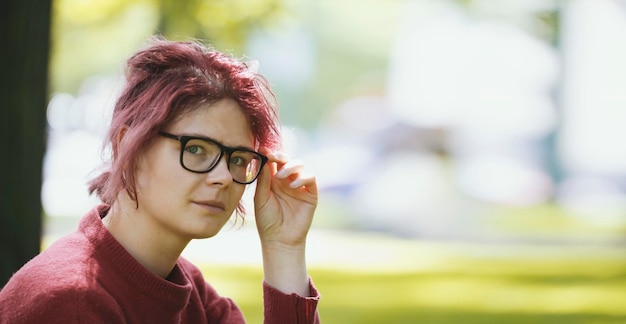 Giovane ragazza adolescente in un parco cittadino estivo, ritratto