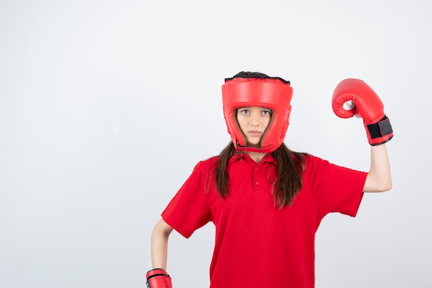 giovane ragazza adolescente in uniforme rossa che indossa guantoni da boxe