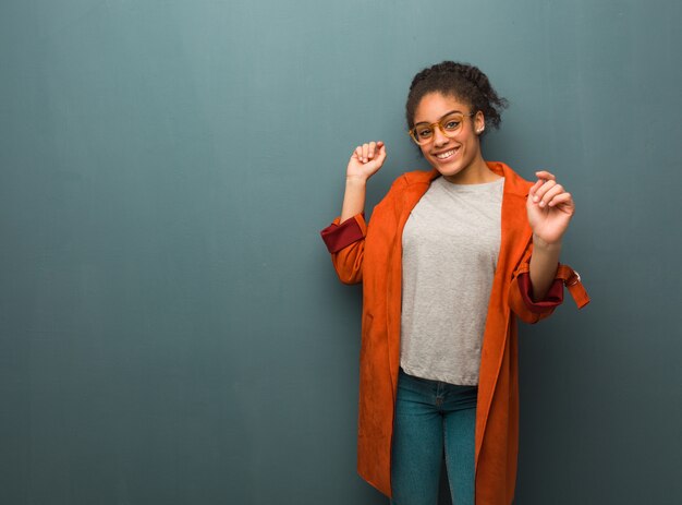 Giovane ragazza afroamericana nera con gli occhi azzurri che ballano e che si divertono