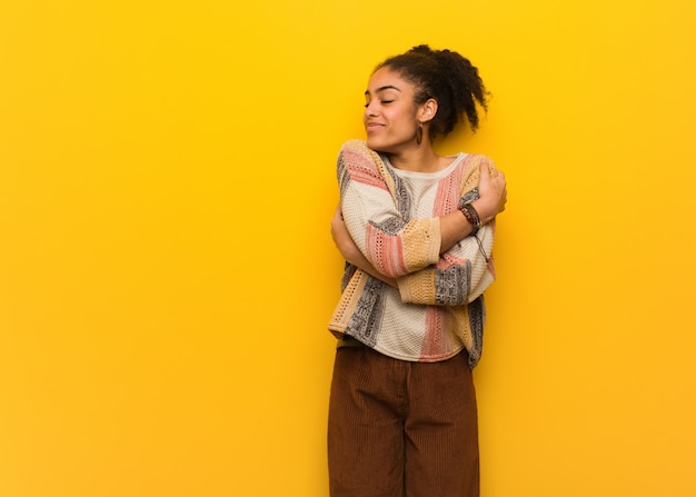 Giovane ragazza afroamericana nera con gli occhi azzurri che dà un abbraccio