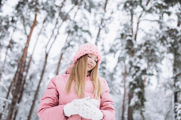 Giovane ragazza all'aperto nel parco innevato d'inverno