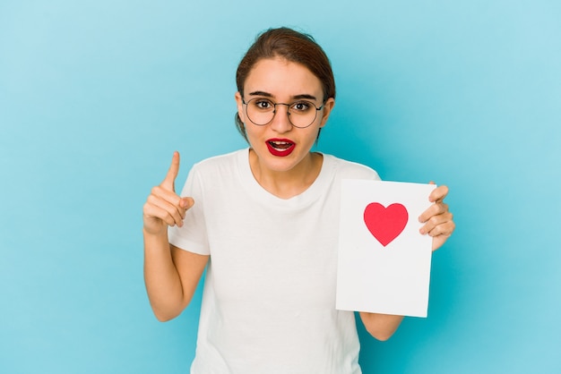 Giovane ragazza araba magra che tiene una carta di San Valentino con un'idea, un concetto di ispirazione.