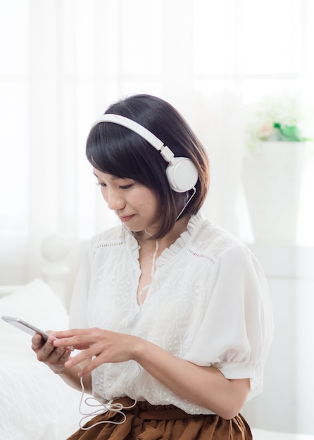 Giovane ragazza asiatica che ascolta la musica a casa