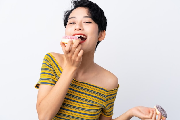 Giovane ragazza asiatica che mangia una ciambella