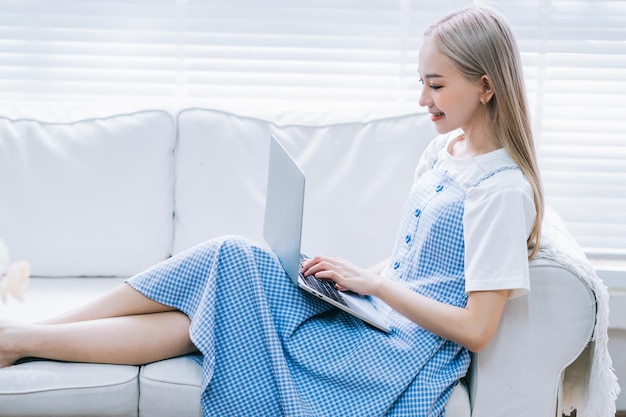 Giovane ragazza asiatica che utilizza il computer portatile a casa