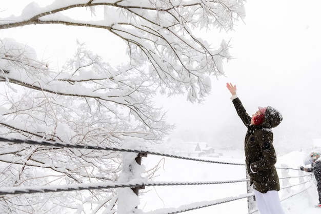 Giovane ragazza asiatica della donna nella stagione di neve di inverno