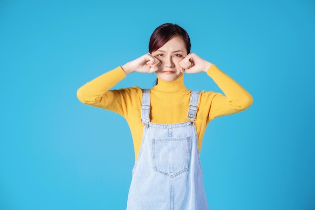 Giovane ragazza asiatica in posa su sfondo blu