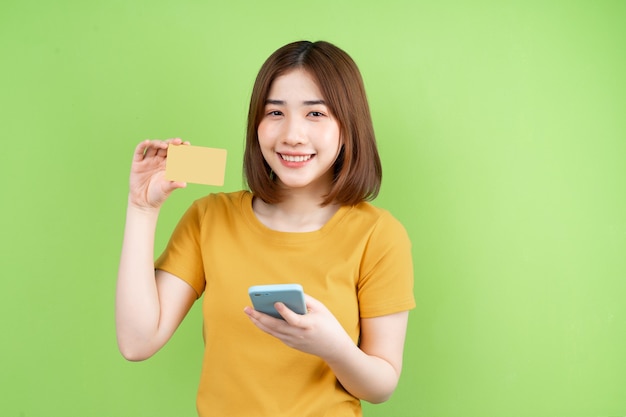 Giovane ragazza asiatica in posa su sfondo verde