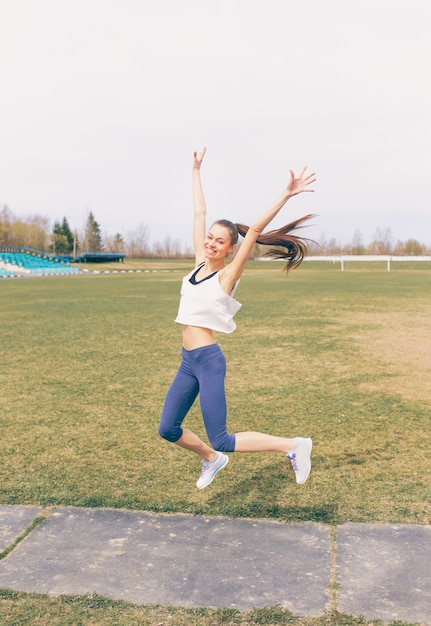 Giovane ragazza atletica facendo esercizio di riscaldamento allo stadio