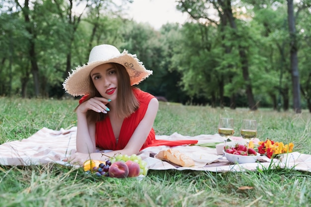 Giovane ragazza attraente su un picnic in un parco cittadino.