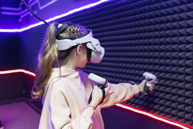 Giovane ragazza bambino che gioca a giochi VR con gli occhiali Cyber spazio e giochi virtuali Concetto di utilizzo delle moderne tecnologie per l'apprendimento