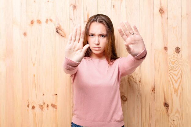 Giovane ragazza bionda contro la parete di legno