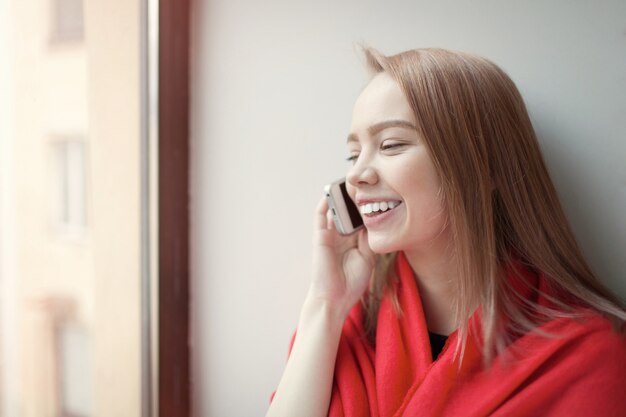 Giovane ragazza bionda parlando al telefono.