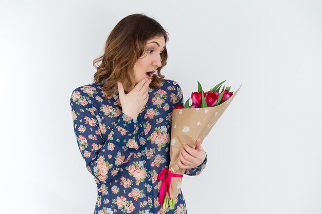 Giovane ragazza carina con bouquet di tulipani rosa