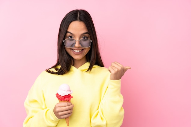 Giovane ragazza castana che tiene un gelato della cornetta isolato