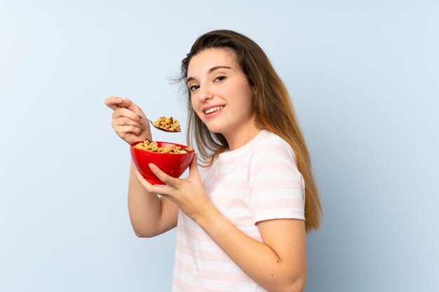 Giovane ragazza castana che tiene una ciotola di cereali