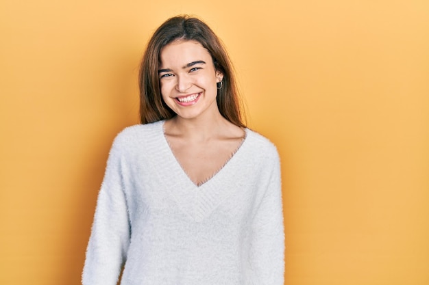 Giovane ragazza caucasica che indossa abiti casual con un sorriso felice e fresco sulla persona fortunata del viso