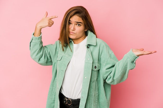 Giovane ragazza caucasica magra dell'adolescente che tiene e che mostra un prodotto a portata di mano.