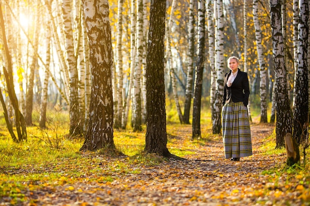 Giovane ragazza che cammina nel parco cittadino di autunno