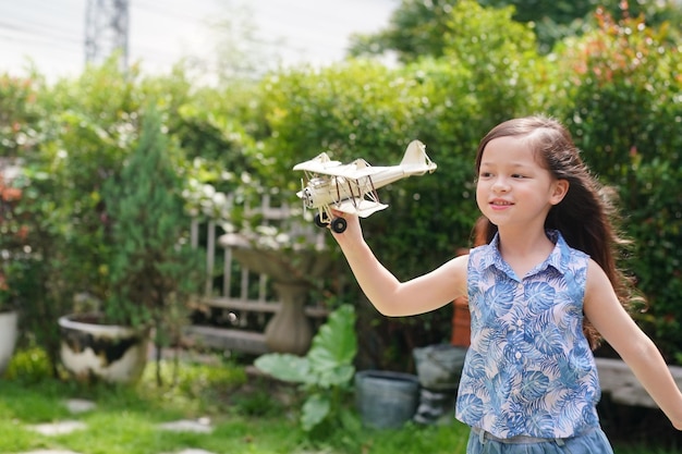 Giovane ragazza che gioca con l'aeroplano giocattolo