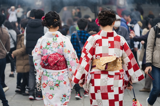 Giovane ragazza che indossa il kimono giapponese in piedi davanti al tempio Sensoji