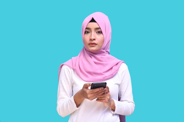 giovane ragazza che indossa l'hijab rosa che tiene il telefono guardando davanti modello pakistano indiano