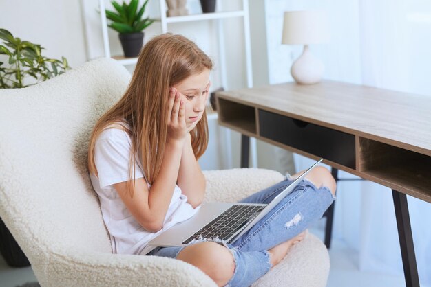 Giovane ragazza che lavora a casa su un computer portatile formazione online