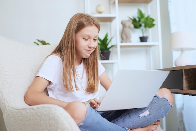 Giovane ragazza che lavora a casa su un computer portatile formazione online