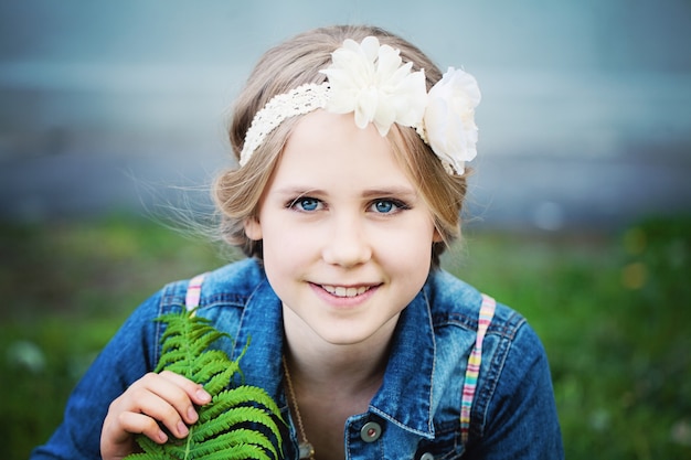 Giovane ragazza con foglia verde all'aperto Tempo di primavera