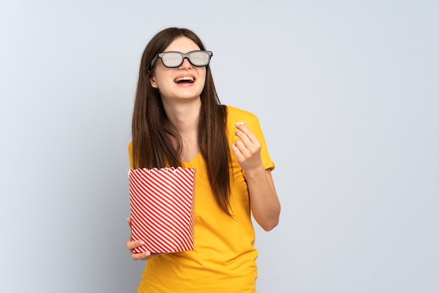 Giovane ragazza con gli occhiali 3d e in possesso di un grande secchio di popcorn